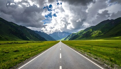A long, straight road stretches through vast, vibrant green meadows, leading towards majestic, steep mountains under a dramatic sky with scattered clouds.
