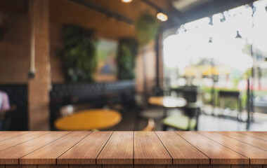 Empty wooden table top with lights bokeh on blur restaurant background.	