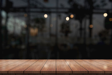 Empty wooden table top with lights bokeh on blur restaurant background.	