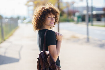 A Young Woman with Gorgeous, Beautiful Curly Hair Happily Strolling and Enjoying the Outdoors