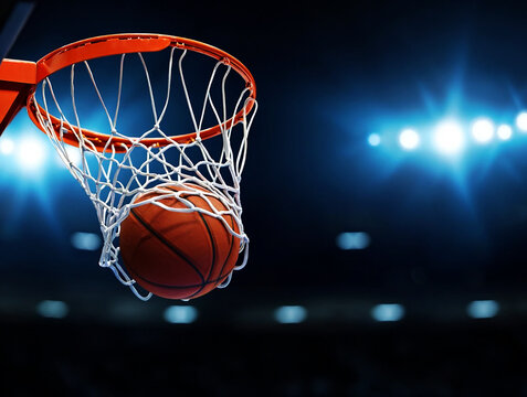 Basketball hoop with ball in net under stadium lights sport