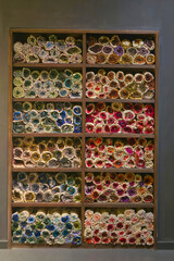 Colorful Rolled Embroidery Thread  Rolls Displayed in Wooden Shelves