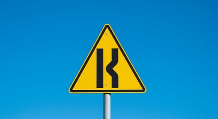 Winding road ahead sign against blue sky