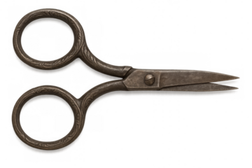 Close-up of vintage sewing scissors featuring ornate floral handles, lying open against a transparent background
