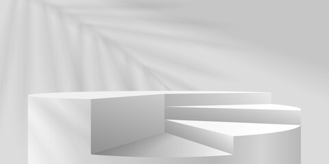 A white cylindrical podium with steps and a shadow from a palm leaf behind it.