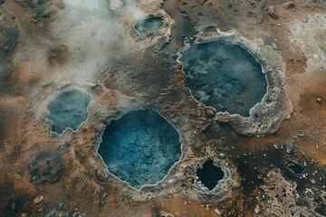 Aerial view of geothermal hot springs with vibrant blue water and mineral deposits