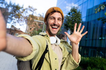Happy tourist taking selfie and waving in city center