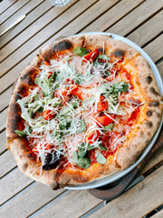 Delicious pizza topped with fresh vegetables served on a wooden table