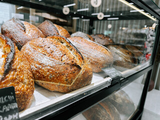 Freshly baked bread loaves displayed in a bakery case during morning hours