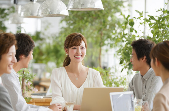 グリーンオフィスで働く女性社員とチームの明るいミーティング風景
