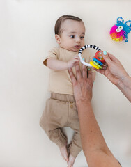 Pediatric physiotherapist uses sensory toy to engage baby and support visual tracking and upper...