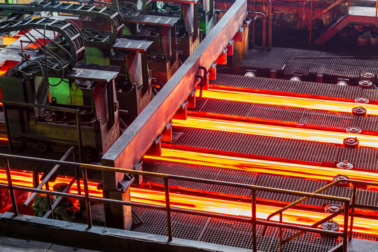 Red hot steel bars on the conveyor belt during the production process in a steel plant