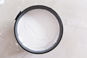 Bucket of white wall paint viewed from above for home renovation or interior improvement concept