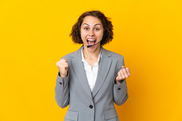 Young English woman isolated on yellow background celebrating a victory in winner position