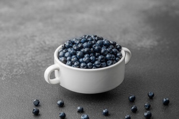Blueberries with scattered berries on grey for healthy snack or food styling concept