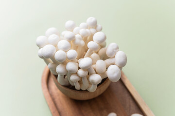 Shimeji mushrooms on wooden board with knife for cooking or preparation concept
