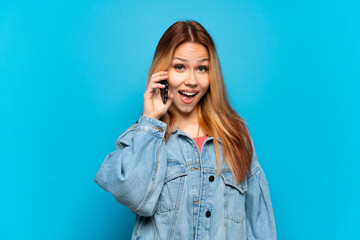 Teenager girl using mobile phone over isolated background with surprise facial expression