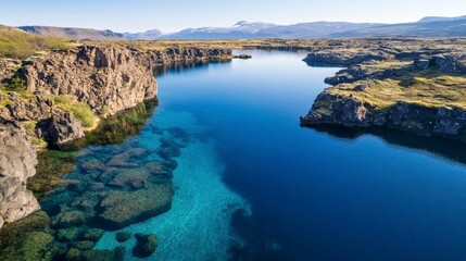 Aerial view of a serene lake nestled between rocky cliffs, showcasing crystal-clear turquoise water and lush greenery.