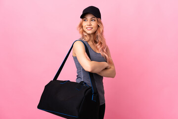 Teenager sport woman with sport bag over isolated background with arms crossed and happy
