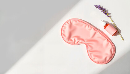 Fototapeta premium A pink sleep mask rests alongside a small lavender sprig and an orange bottle of essential oil, creating a serene environment for relaxation and sleep preparation
