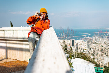 Girl with a camera. A young tourist travels around the city and films the sights on camera. The...