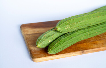 Fresh Angled luffa (Ribbed Gourd) fruits on wooden cut. nutrition ingredient.