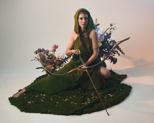Full length portrait of female model figure wearing green fantasy fae hooded cloak crown headdress...