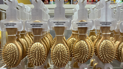 Rows of combs in many colors displayed in a shop. Goods neatly arranged in a display case