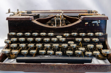 Close up of an old dirty and rusty typewriter on a white background with the concpet that the past...