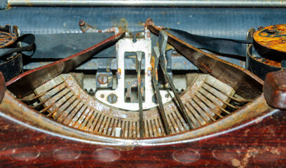 Close up of the typeface of an old rusty typewriter with some of the letters stuck in the up...
