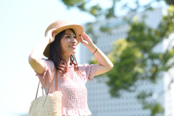 麦わら帽子を被った若い笑顔のアジア人女性