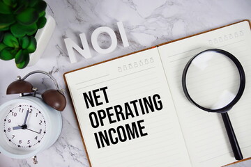NOI - Net Operating Income acronym on notepad, Business concept background