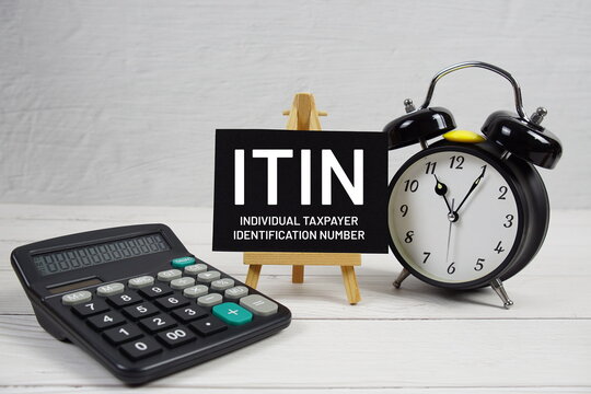 ITIN Individual Taxpayer Identification Number text with alarm clock on wooden background