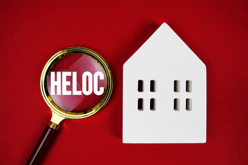 HELOC Home Equity Lines Of Credit text with house model on red background