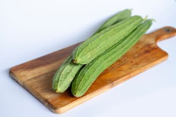 Fresh Angled luffa (Ribbed Gourd) fruits on wooden cut. nutrition ingredient.