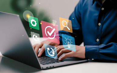 A digital illustration of hands typing on a silver laptop keyboard with floating holographic icons.