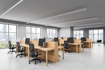 Modern open space office interior with wooden desks and computer workstations in a high-rise...