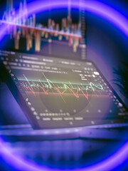 Tablet showing volatile stock chart in neon light