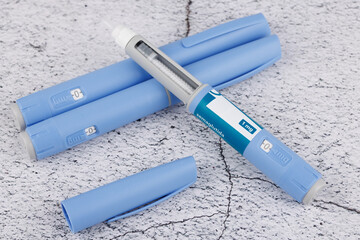 Minimalist flat lay with semaglutide pens and measuring tape on concrete base, symbolic image of diabetes control and weight therapy
