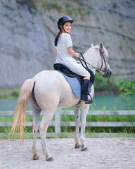 Asian Young Woman Horseback Riding in Nature Training Ground. The Sport and Recreation a relaxing...