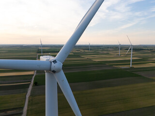 Aerial view of wind turbine on an agricultural filed at sunset. Close up of blades