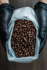 Freshly roasted coffee beans held in gloved hands in a cozy indoor setting
