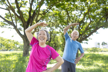 Happy asian senior couple exercising in the park.