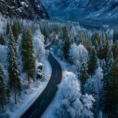 Winding road through a snow covered forest and mountain valley winter mountains