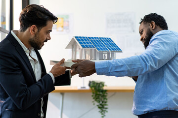team of multiethnic coworker working on solar roof system project with house model, responsible of...