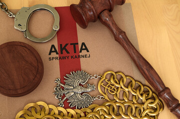 Attributes of the justice system, handcuffs, files, documents, a judge's gavel and chain lying on a desk