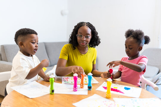 Mother and children painting together at home