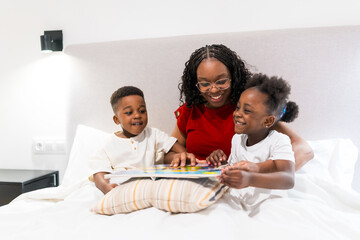 Mother reading a bedtime story to her children