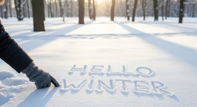 Woman writing hello winter with finger on fresh snow in sunny park. Outdoor season greeting for holiday advertisement. - Powered by Adobe