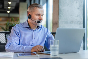 Smiling friendly handsome middle aged male call center operator.